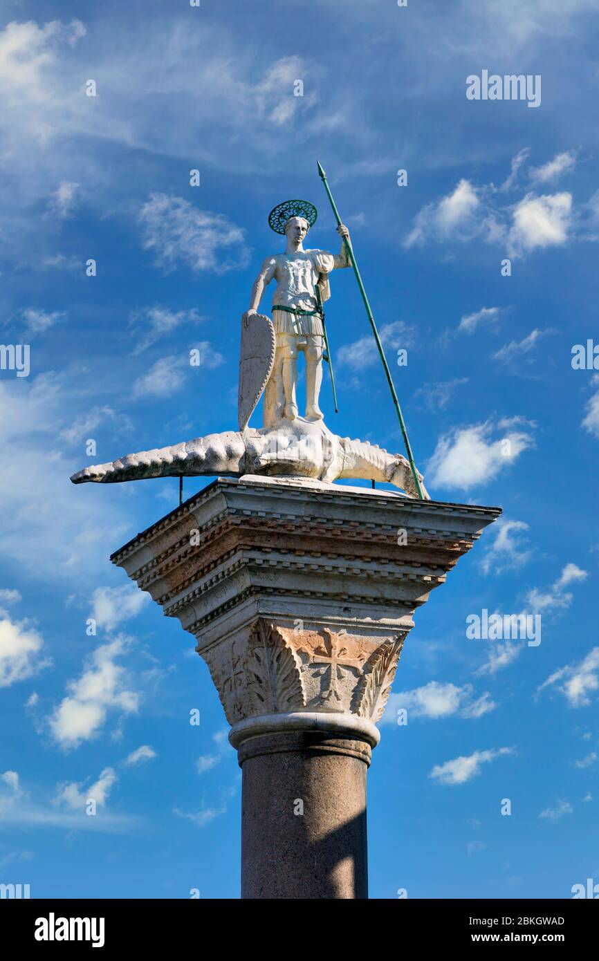 Venezia, Provincia di Venezia, Regione Veneto, Italia. Statua di San Teodoro sulla cima della colonna di granito nella Piazzetta. Ha una lancia in mano e il suo foo Foto Stock