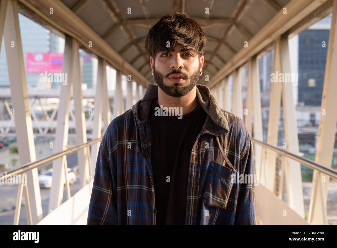 Giovane bell'uomo indiano barbuto hippster al ponte pedonale Foto Stock