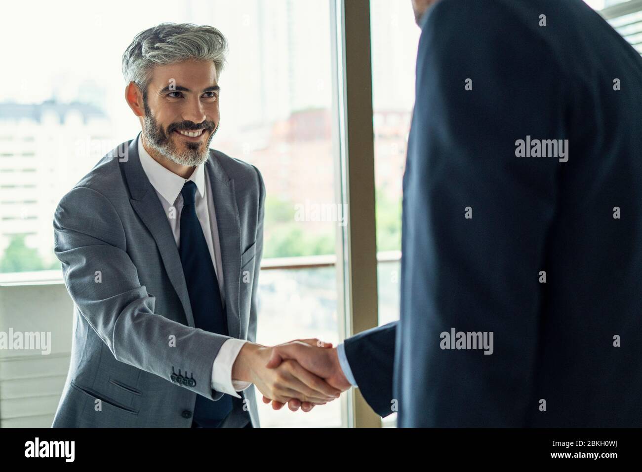 Uomini d'affari si stringono la mano in ufficio Foto Stock