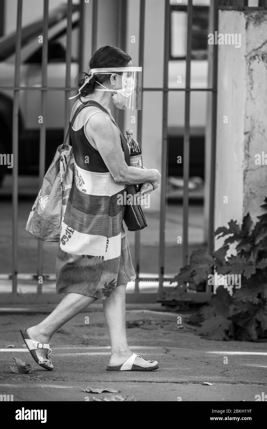 Persone reali preoccupate, protette con maschere e a piedi che trasportano borse di shopping nelle strade di Providencia durante la malattia di infezione da coronavirus COVID-19 Foto Stock