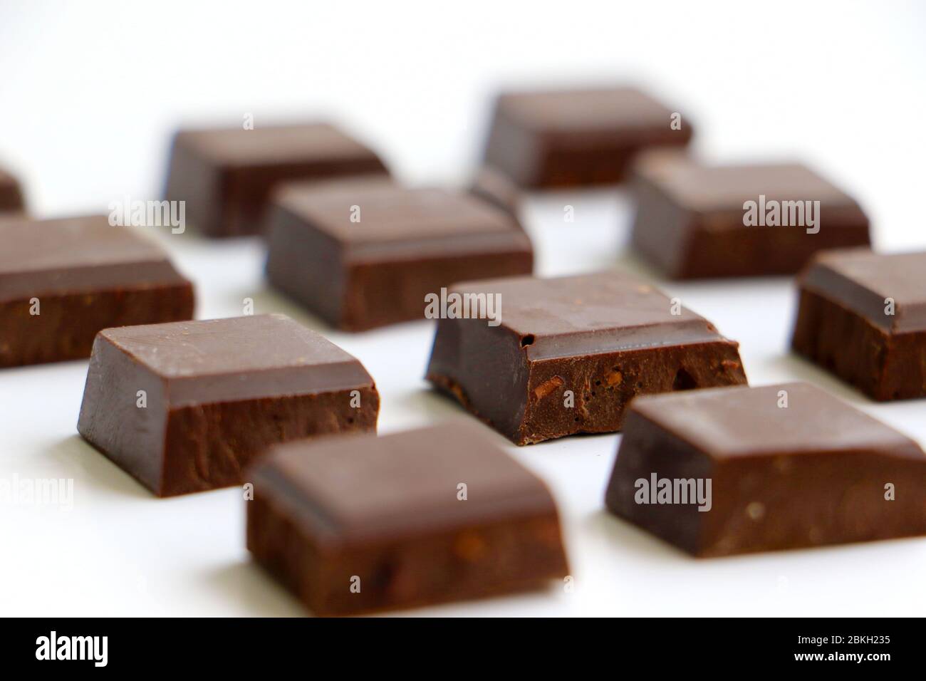 spezzato pezzi di cioccolato in un piccolo mucchio isolato su sfondo bianco Foto Stock
