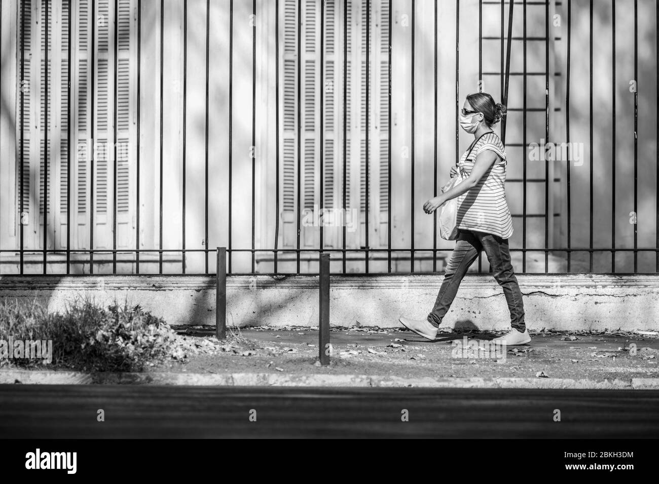 Una donna incinta preoccupata e camminata nelle strade di Providencia durante l'infezione da coronavirus COVID-19 con protezione della distanza e della maschera Foto Stock