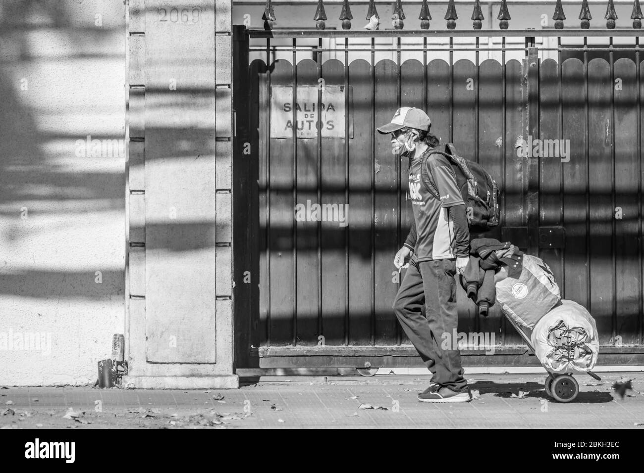 Persone reali preoccupate, protette con maschere e a piedi che trasportano borse di shopping nelle strade di Providencia durante la malattia di infezione da coronavirus COVID-19 Foto Stock