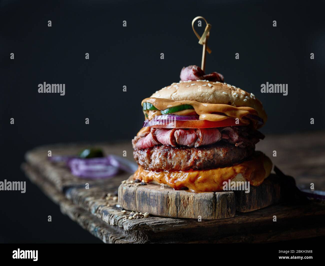 hamburger di bistecca fresco e gustoso su vecchio tavolo di legno Foto Stock