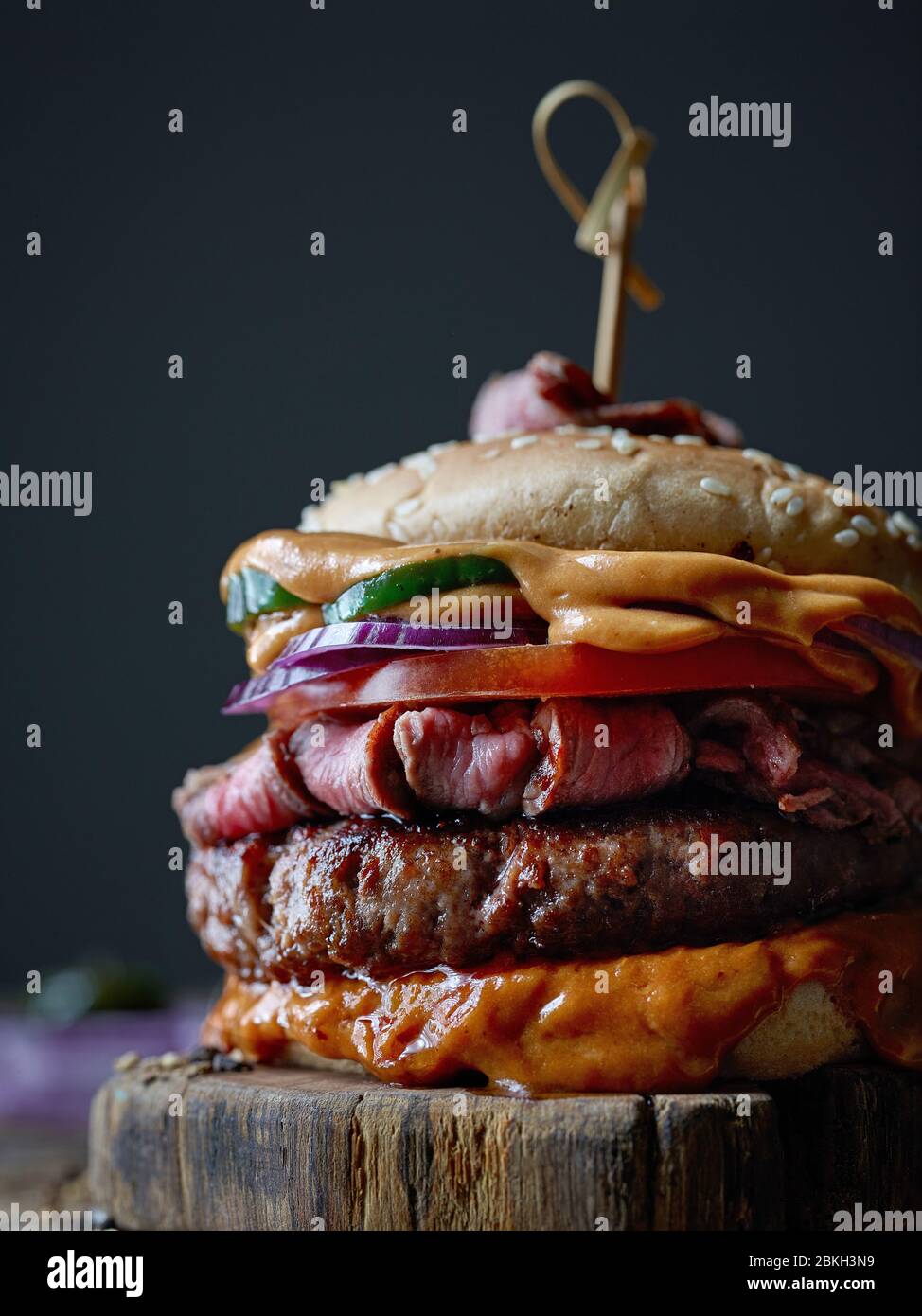 hamburger di bistecca fresco e gustoso su vecchio tavolo di legno Foto Stock