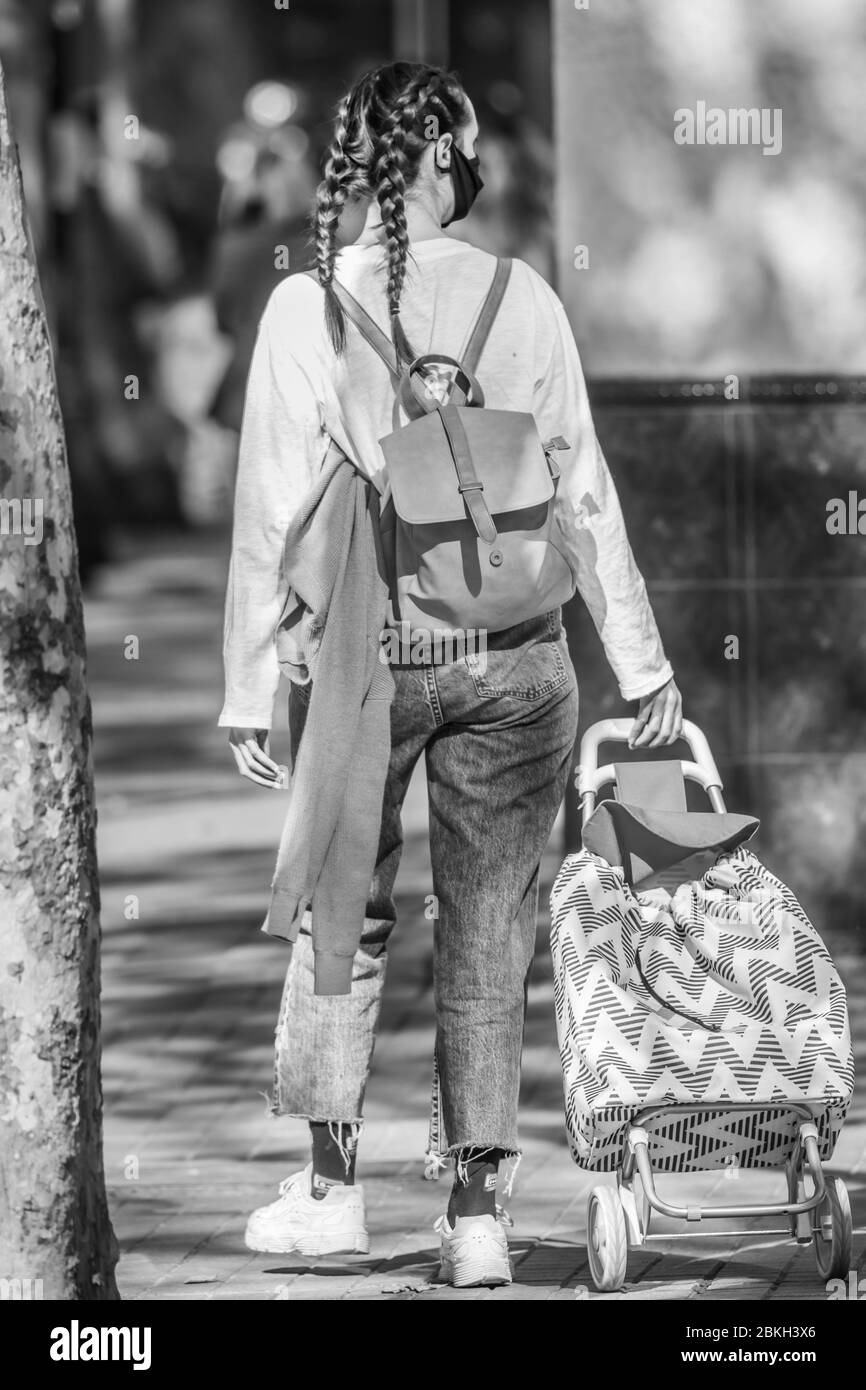 Persone reali preoccupate, protette con maschere e a piedi che trasportano borse di shopping nelle strade di Providencia durante la malattia di infezione da coronavirus COVID-19 Foto Stock