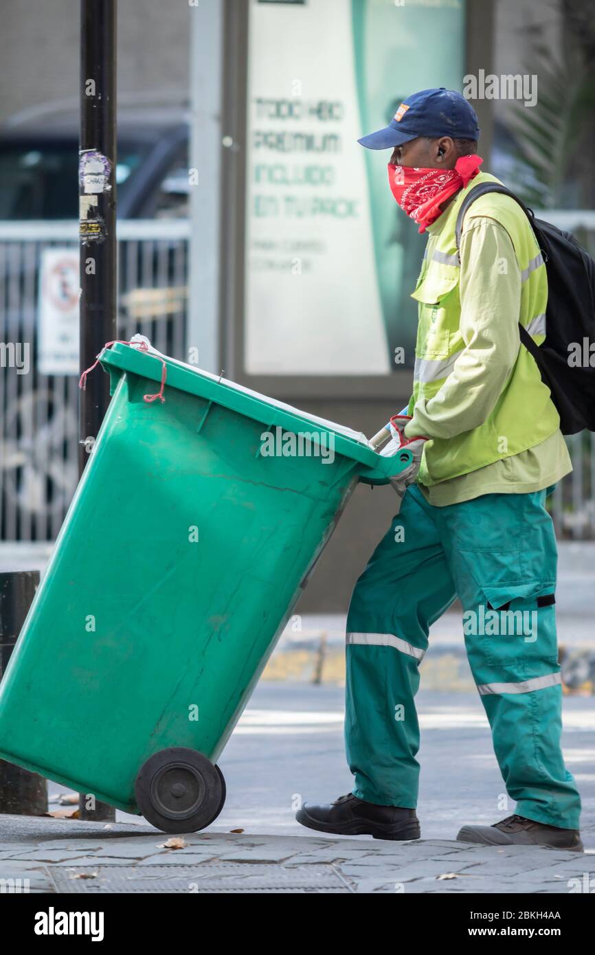 Lavoratore immigrato addetto alla pulizia preoccupato mentre lavora a Santiago strade pulizia durante infezione da coronavirus COVID-19 con precaria protezione Foto Stock