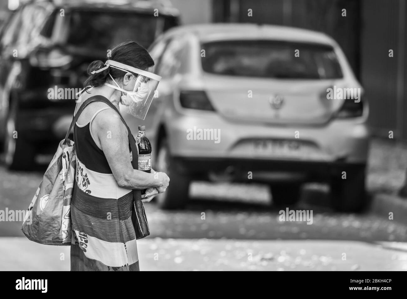 Persone reali preoccupate, protette con maschere e a piedi che trasportano borse di shopping nelle strade di Providencia durante la malattia di infezione da coronavirus COVID-19 Foto Stock