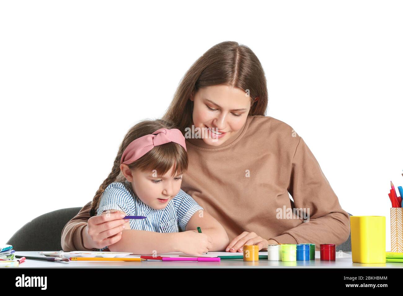 Insegnante di disegno che dà lezioni private di arte a bambina su sfondo bianco Foto Stock