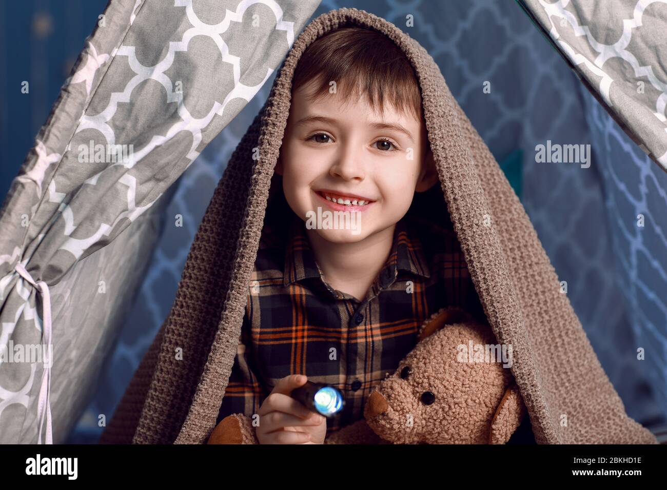 Carino ragazzo con torcia in tenda di gioco di notte Foto Stock