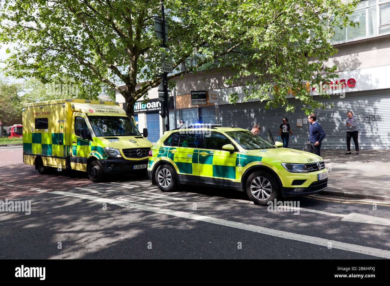 Due veicoli London Ambulance arrivano fuori dal negozio Bright House chiuso, in Lewisham Hight Street, per assistere a un'emergenza medica, durante la Pandemic COVID-19 Foto Stock