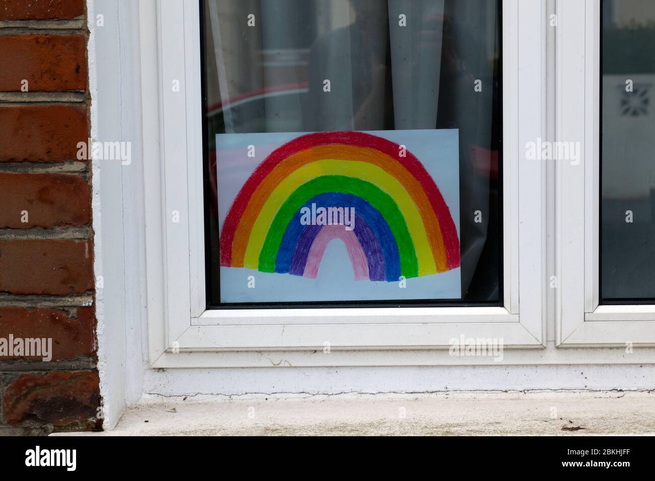 Le immagini dei Rainbow sono comunemente esposte in molte finestre di popoli durante il blocco di Covid-19, come gesto di solidarietà Foto Stock