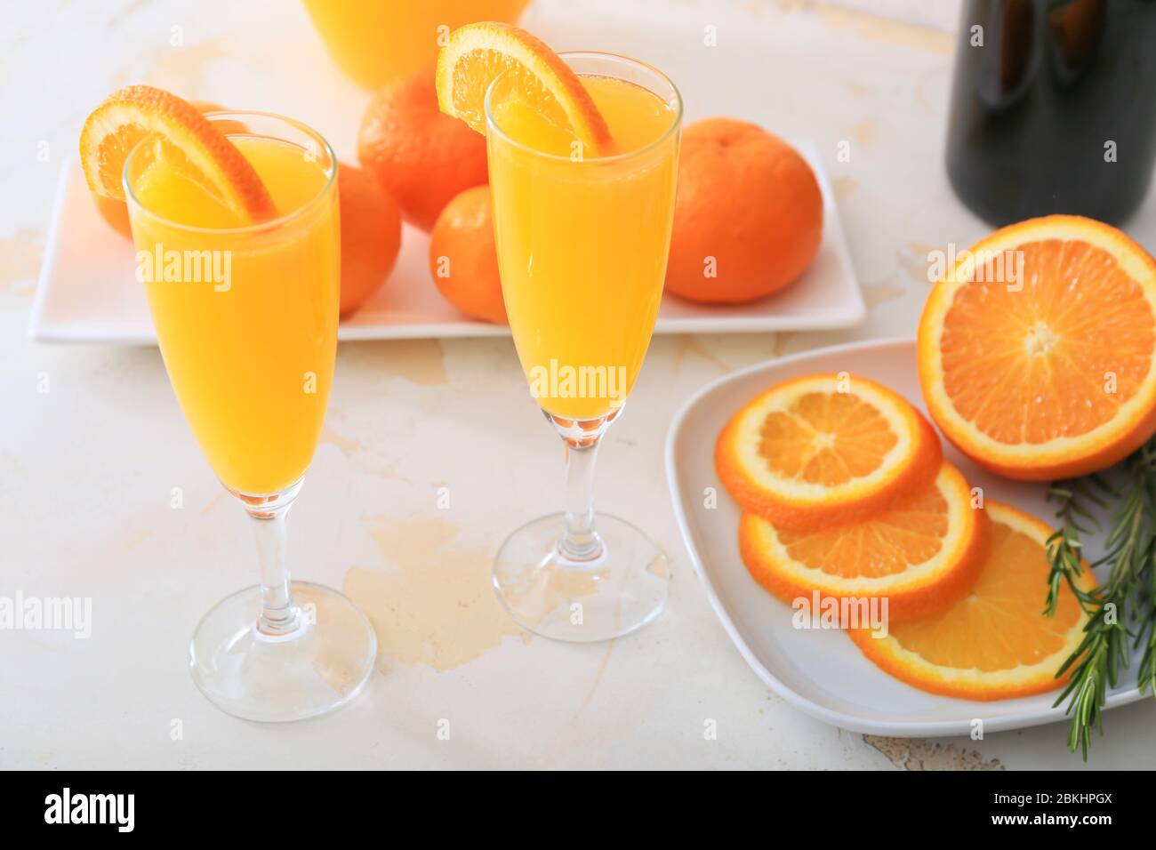 Bicchieri di gustosi cocktail mimosa al tavolo Foto Stock