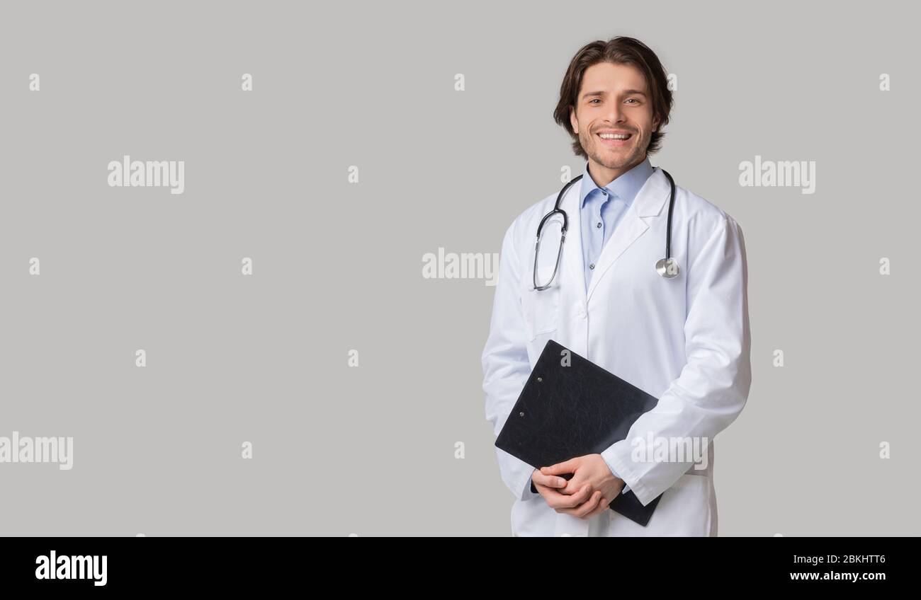 Ritratto di Happy Intern Doctor in uniforme con Clipboard in mano Foto Stock