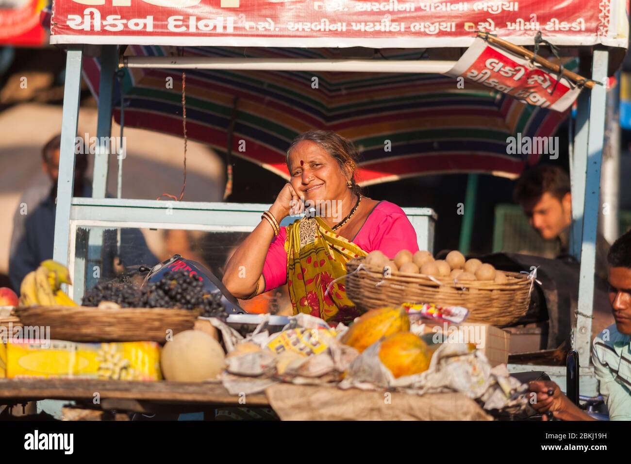 India, Stato del Gujarat, Ahmedabad, ritratto di una donna sorridente che vende frutta per strada Foto Stock