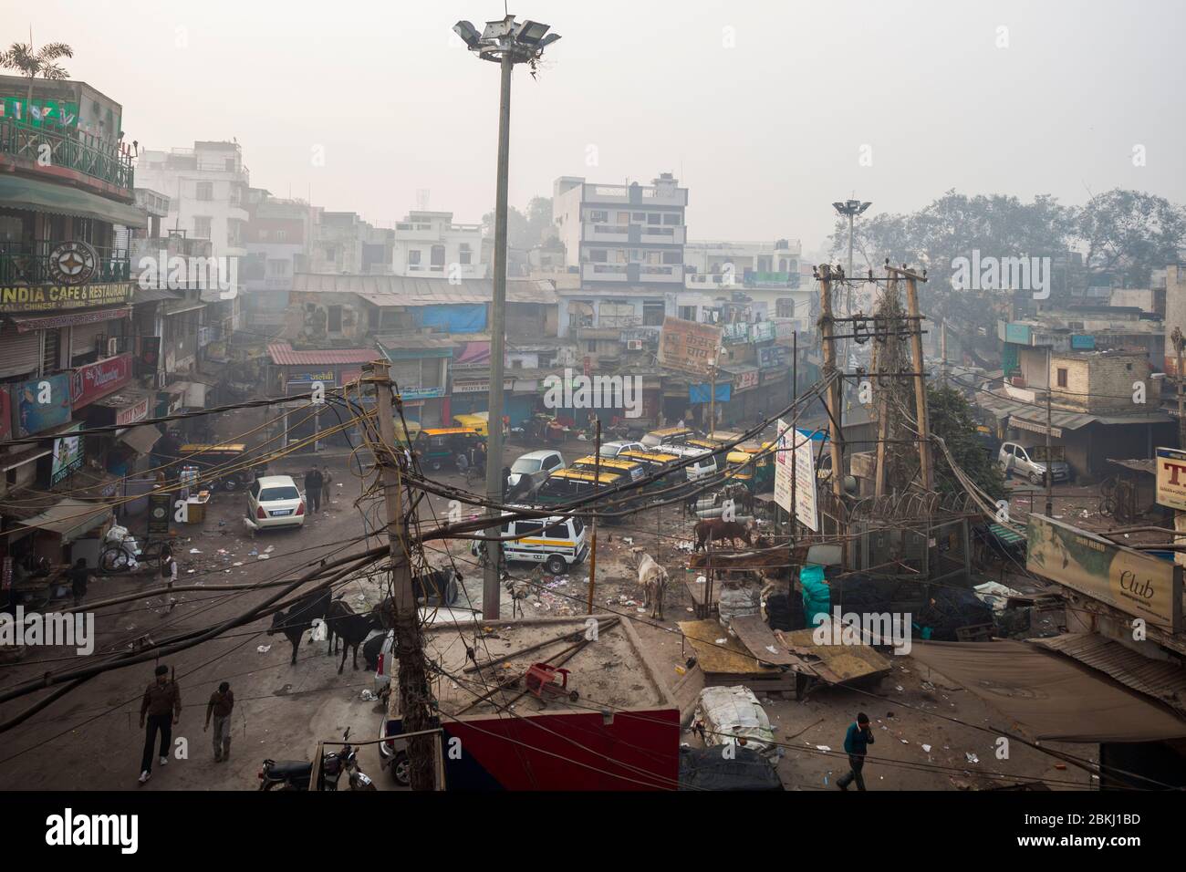 India, territorio della capitale nazionale di Delhi, Nuova Delhi, distretto di Paharganj, vista elevata su un incrocio affollato di passanti, mucche, veicoli e negozi Foto Stock