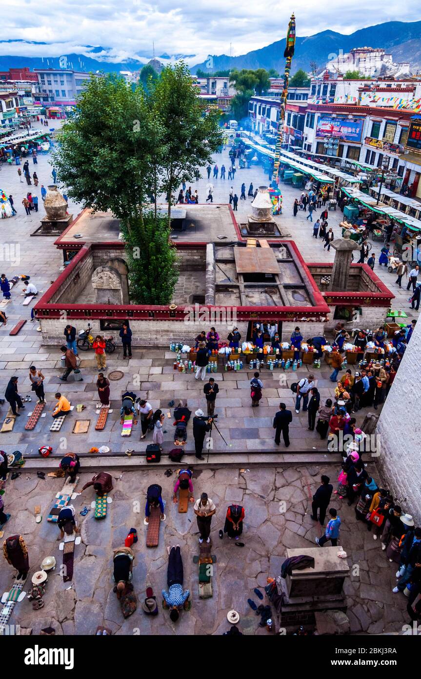 Cina, Tibet centrale, Ü Tsang, Lhasa, tempio di Jokhang, il santuario più venerato del Tibet, folla in prostrazione fuori dall'ingresso Foto Stock