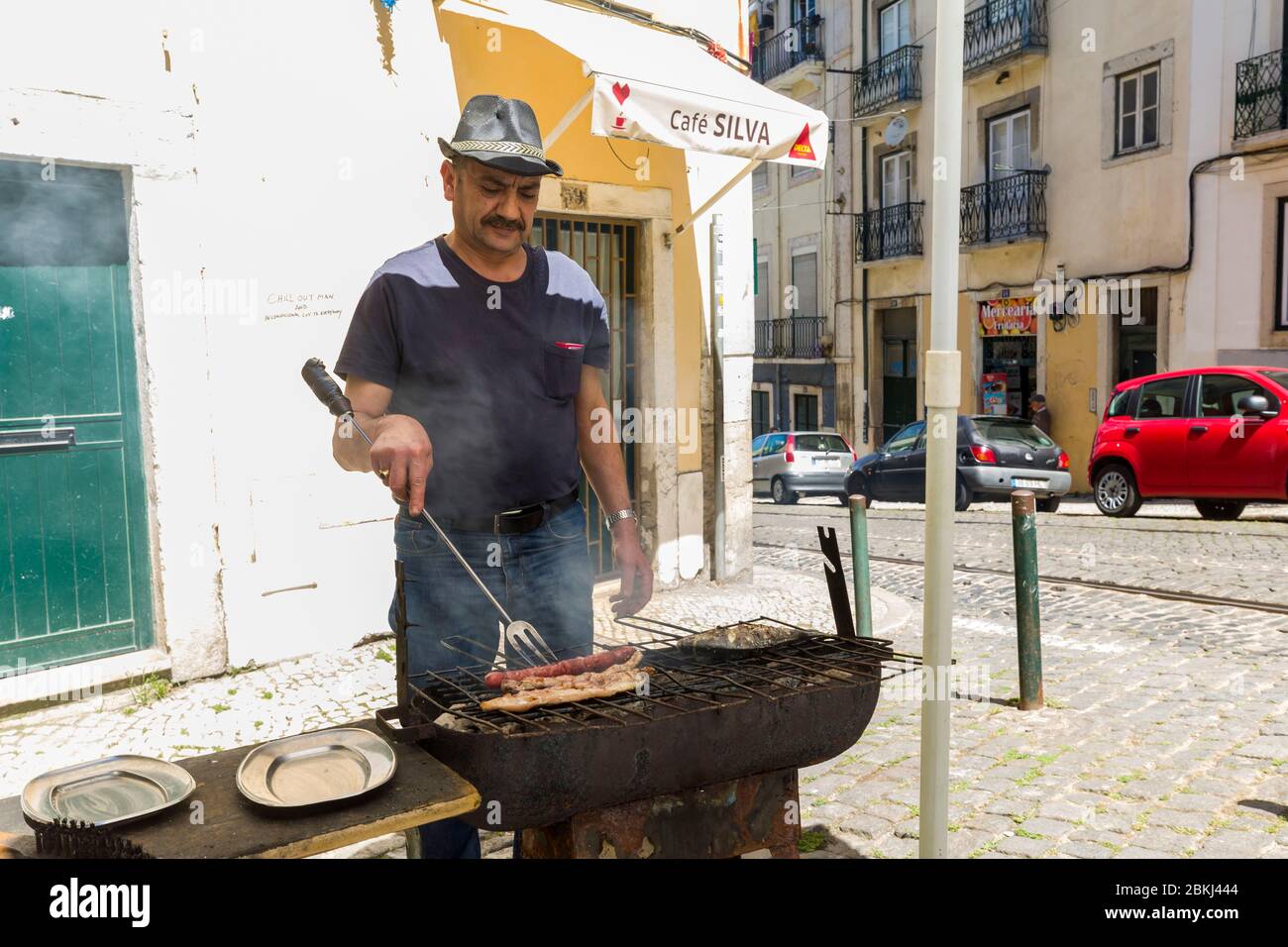 Portogallo, Lisbona, Graça, uomo che cucina un pasto per strada Foto Stock