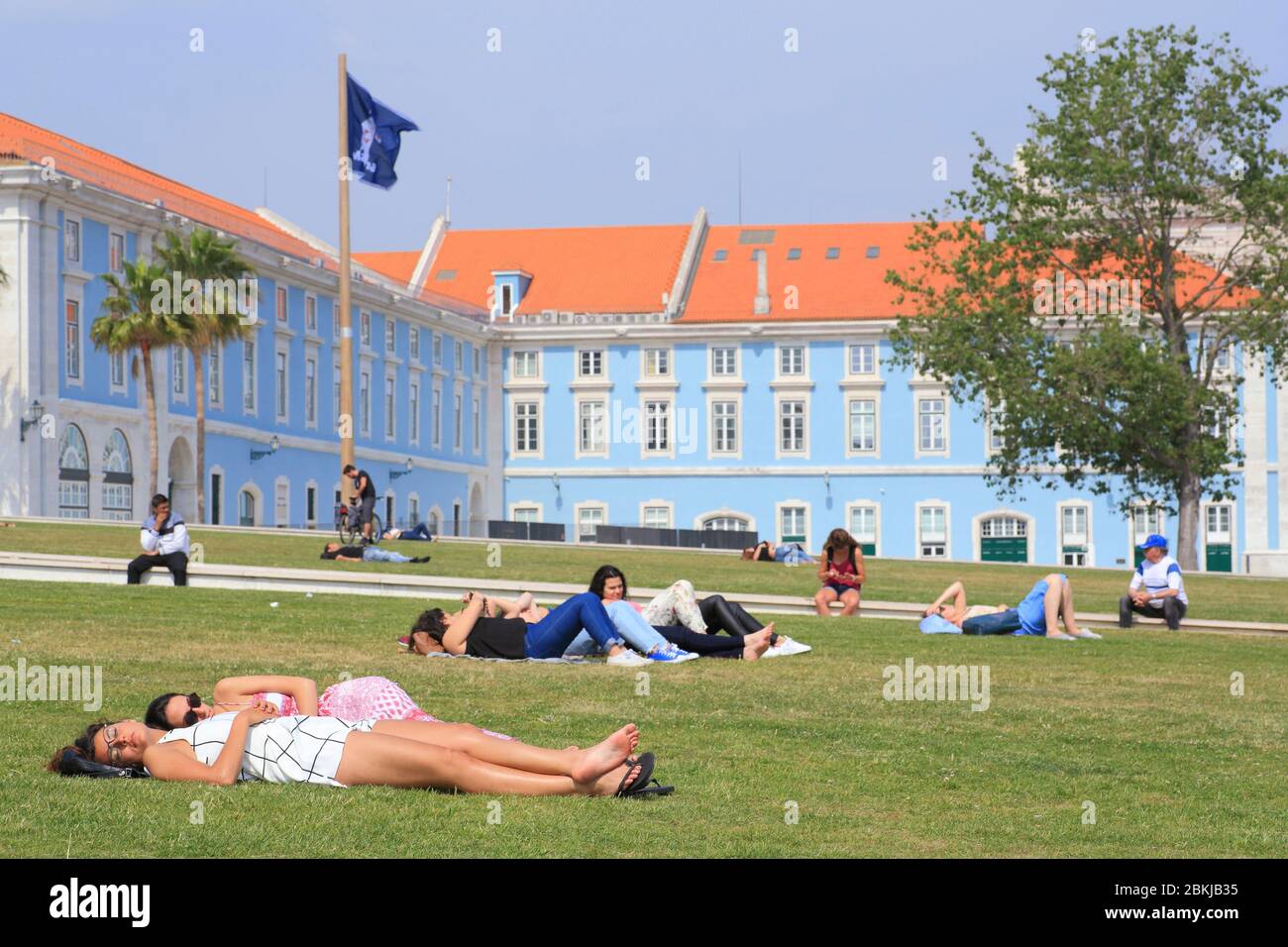 Portogallo, Lisbona, Ribeira das Naus, solarium sul prato con edifici governativi sullo sfondo Foto Stock