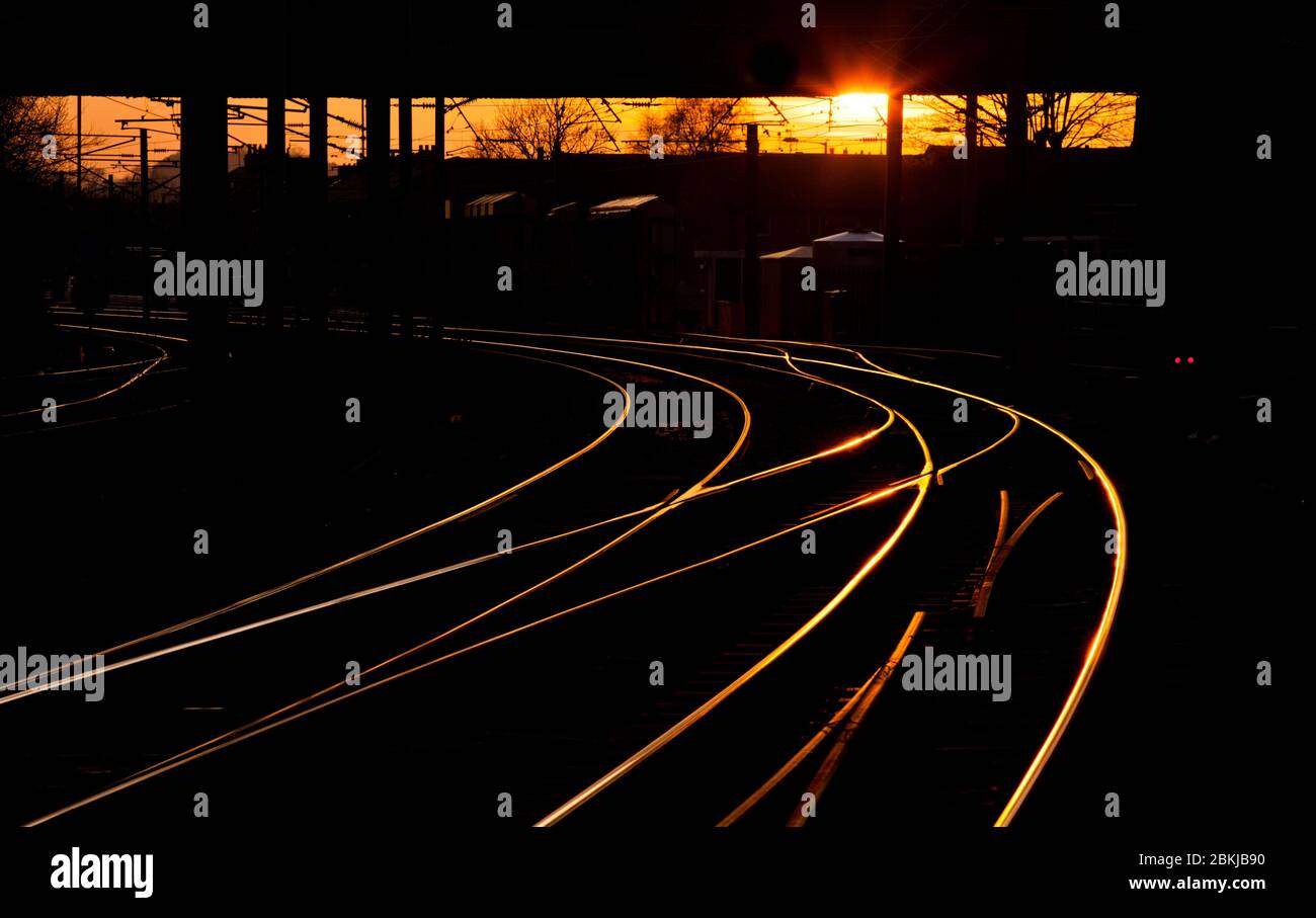 Tramonto sulla linea ferroviaria con i punti di incrocio all'estremità ovest della stazione di Skipton Foto Stock