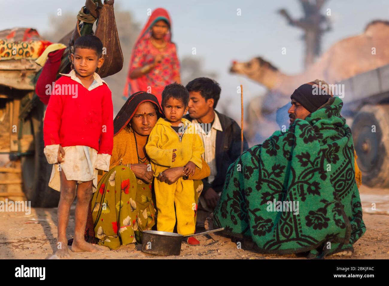 India, Rajasthan, Nagaur, fiera del bestiame, famiglia di nomadi nel campo e cammelli Foto Stock
