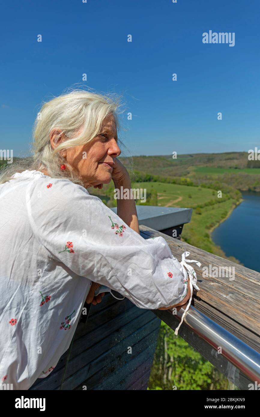 Europa, Lussemburgo, Insenborn, attraente donna anziana godendo la vista del Lac Sûre dalla piattaforma di osservazione Belvédère Foto Stock