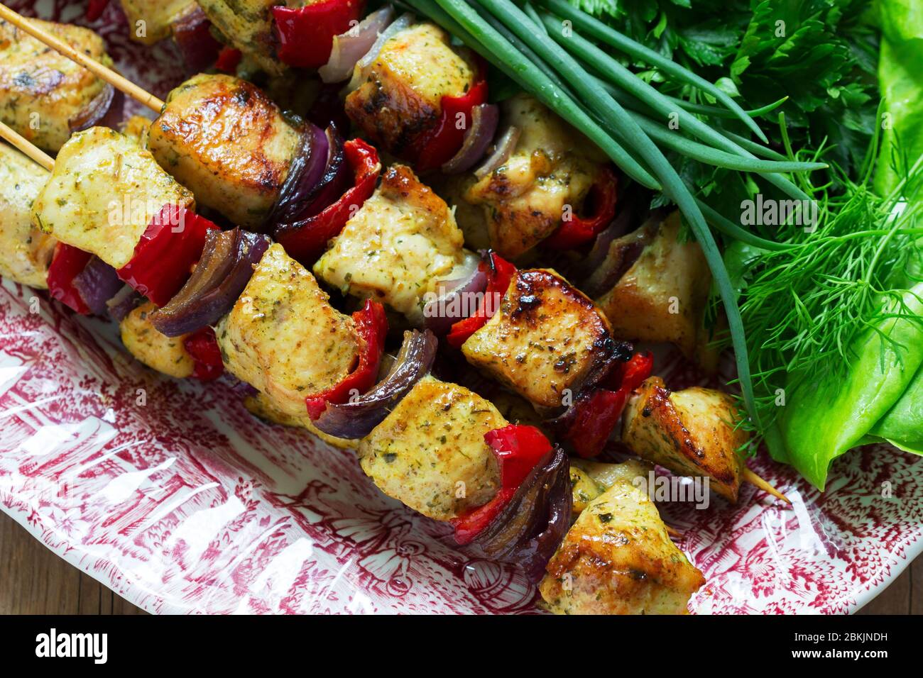 Kebab di pollo con verdure servite con varie erbe e salsa. Foto Stock