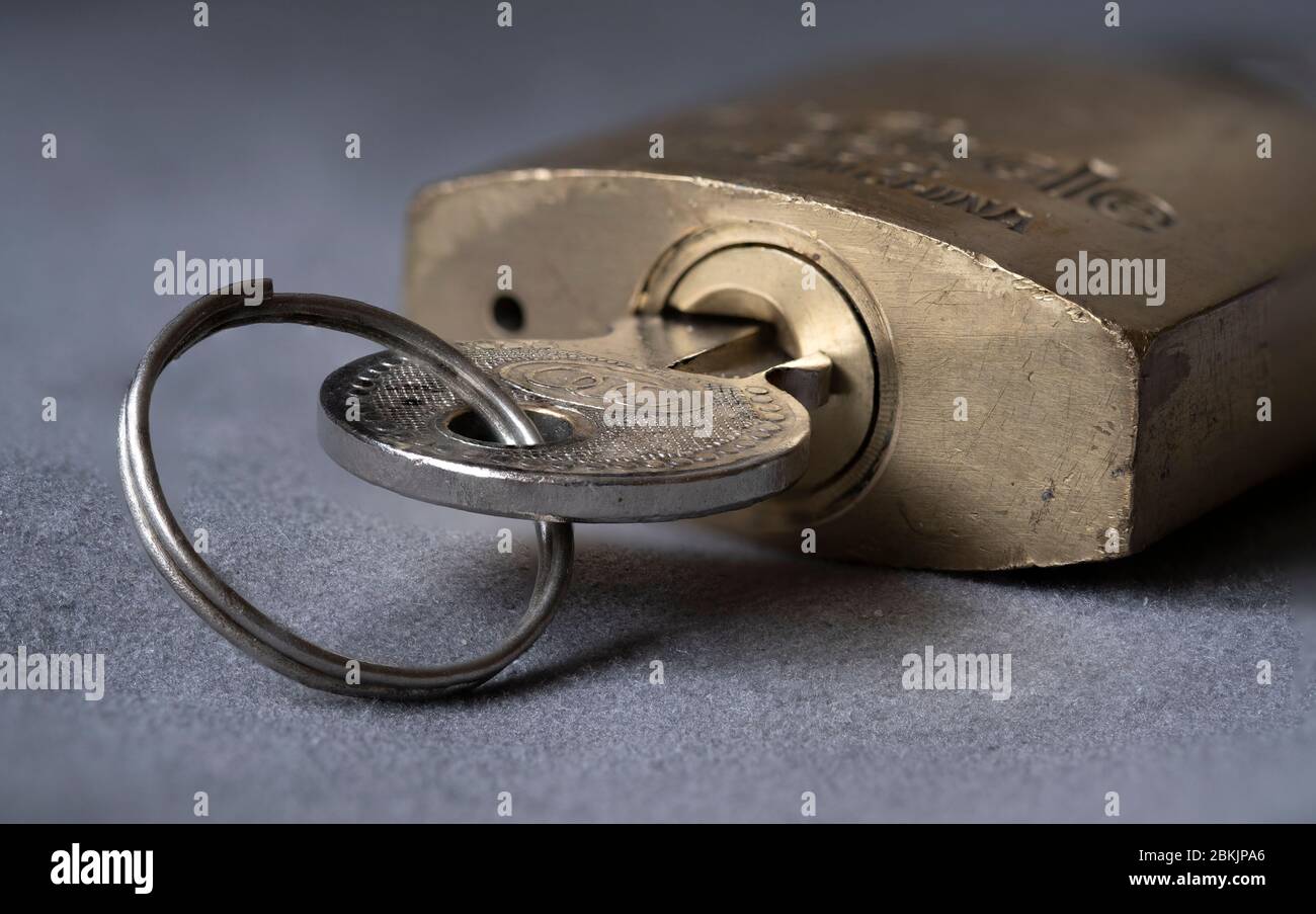 Primo piano di un lucchetto in ottone con chiave inserita nella serratura. Foto Stock