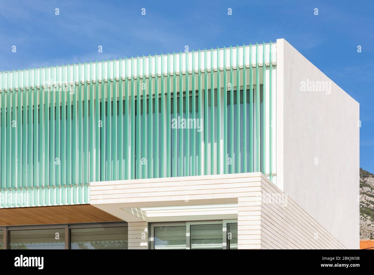 Bol, Croazia, 10 settembre 2019. Una facciata di un hotel con belle linee turchesi verticali in una giornata di sole in estate con un cielo blu. Arco moderno Foto Stock