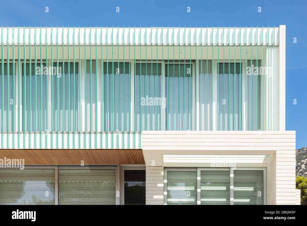 Bol, Croazia, 10 settembre 2019. Una facciata di un hotel con belle linee turchesi verticali in una giornata di sole in estate con un cielo blu. Arco moderno Foto Stock