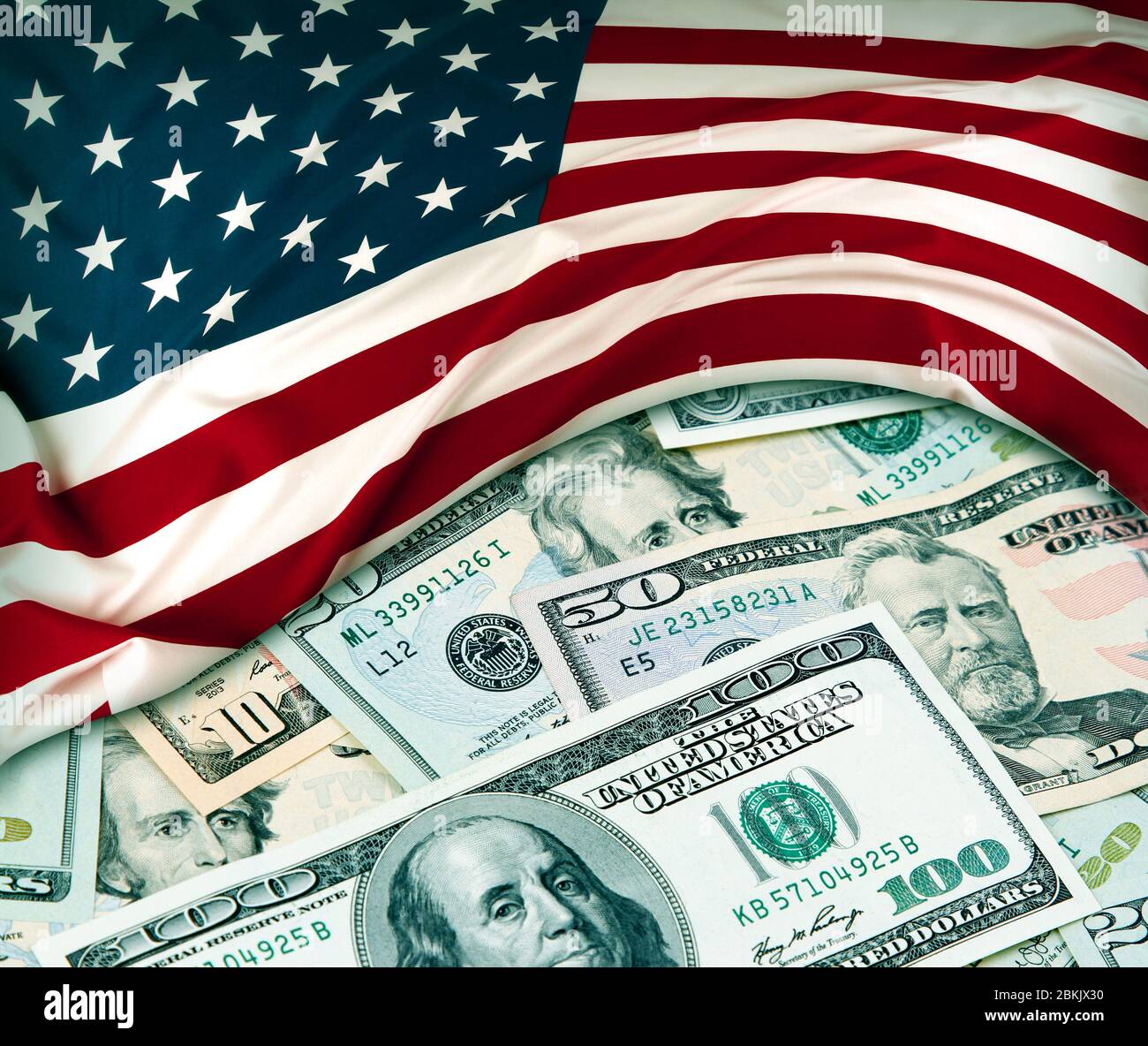 Bandiera americana e un assortimento di banconote americane Foto Stock