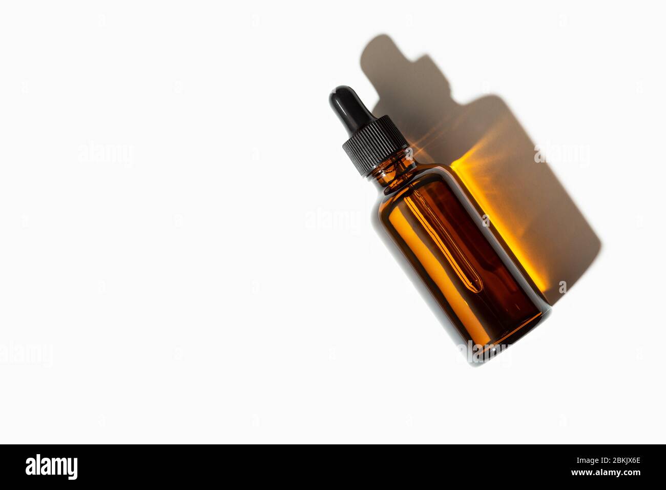 Flacone di vetro per olio essenziale o siero con pipetta isolata su fondo bianco. Spazio di copia Foto Stock