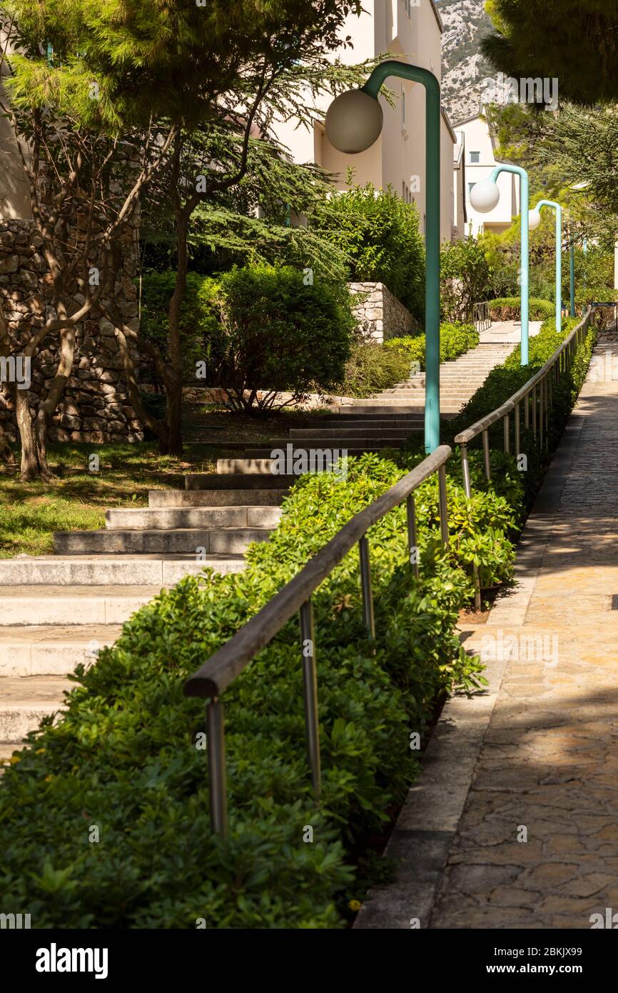 Bol, Croazia, 10 settembre 2019. Scale con alberi e verde vicino al viale sull'isola di Brac in Dalmazia. Lanterne moderne accanto al percorso. Rel Foto Stock