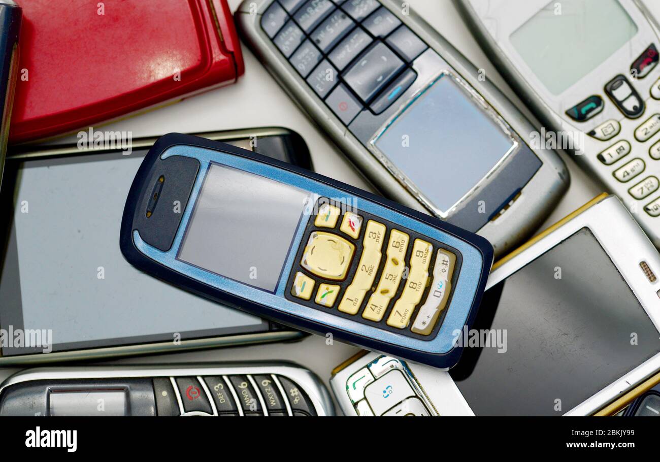 pile di vecchi telefoni cellulari usati danneggiati tecnologia sfondo Foto Stock