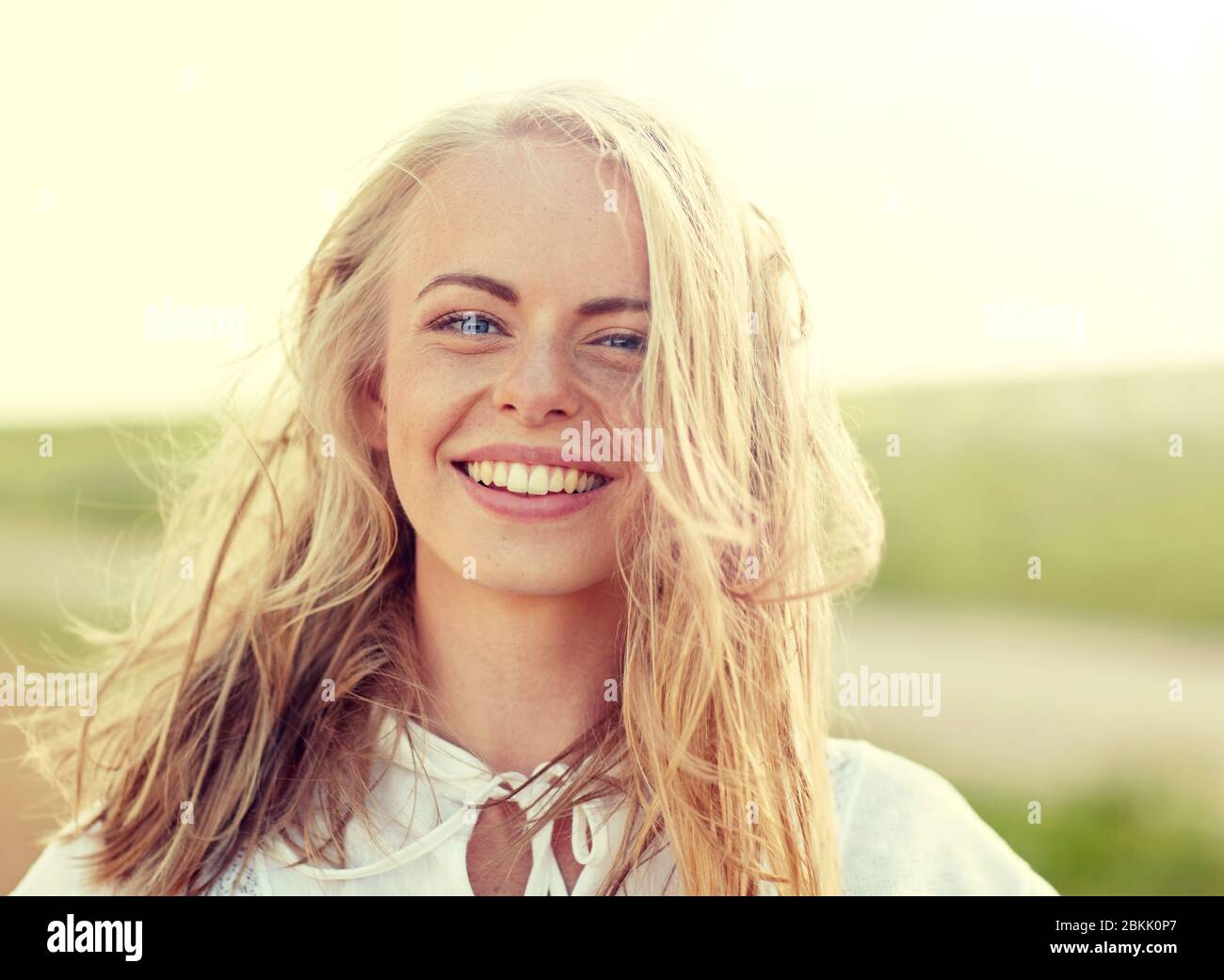 Close up di felice giovane donna in bianco all'aperto Foto Stock