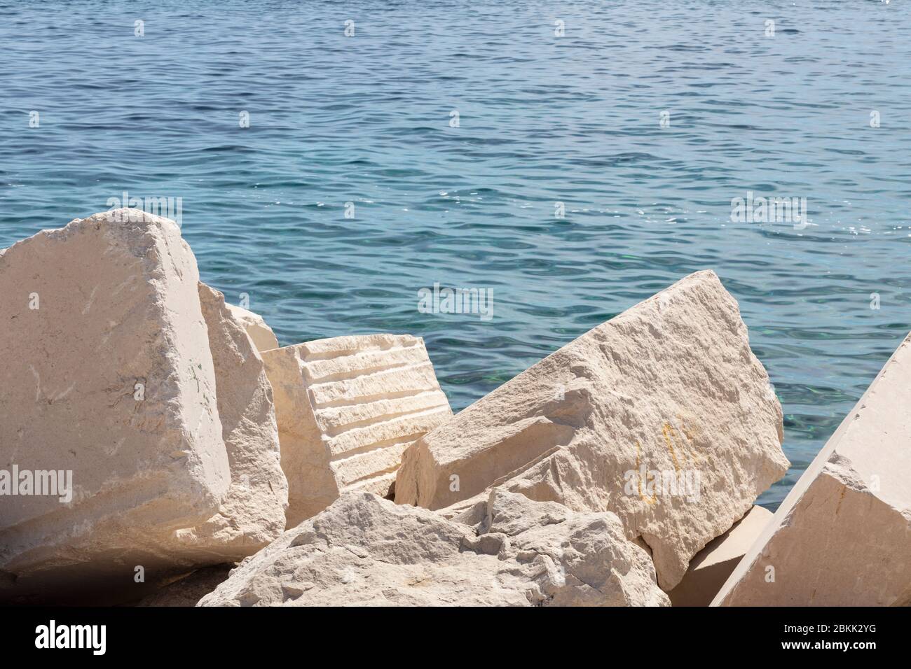 Bella pietra calcarea bianca grande blocchi a Bol, Brac, Dalmazia, Croazia e il mare Adriatico sullo sfondo. Pietre famose usate per pietra ma Foto Stock