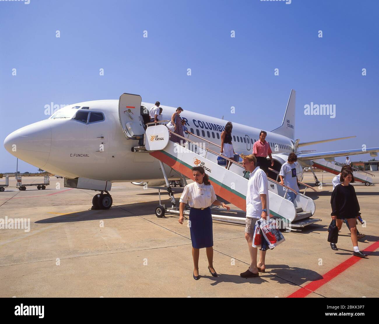 I passeggeri sbarcano Air Columbus (ora defunta) Boeing 737 all'Aeroporto di Faro, Faro, Algarve, Portogallo Foto Stock