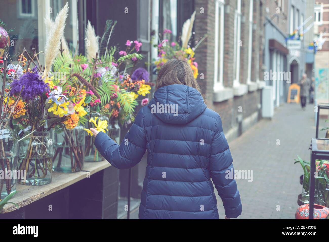 Giovane donna sorridente che seleziona fiori freschi Foto Stock