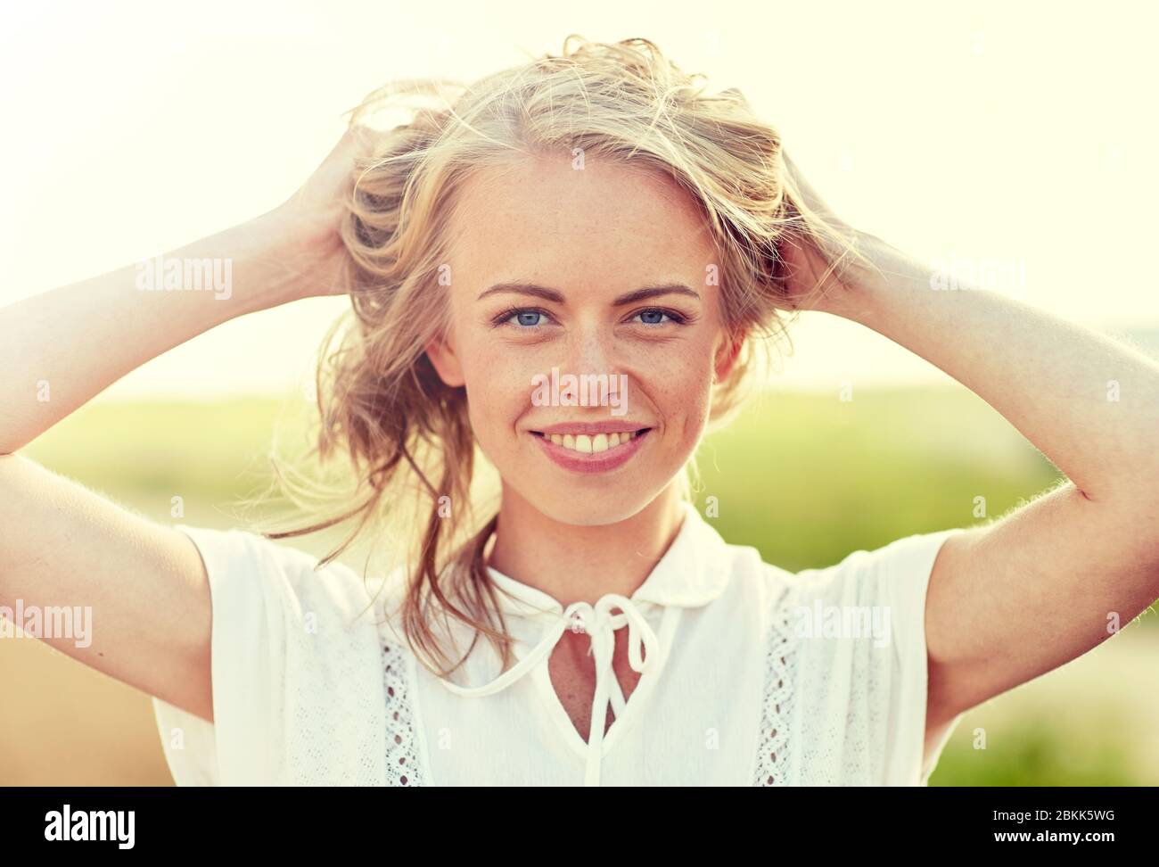 Close up di felice giovane donna in bianco all'aperto Foto Stock