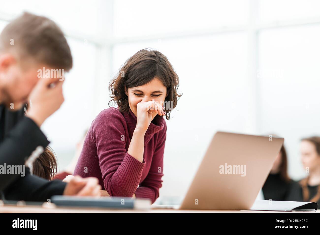 giovani che discutono di qualcosa che siede al tavolo Foto Stock