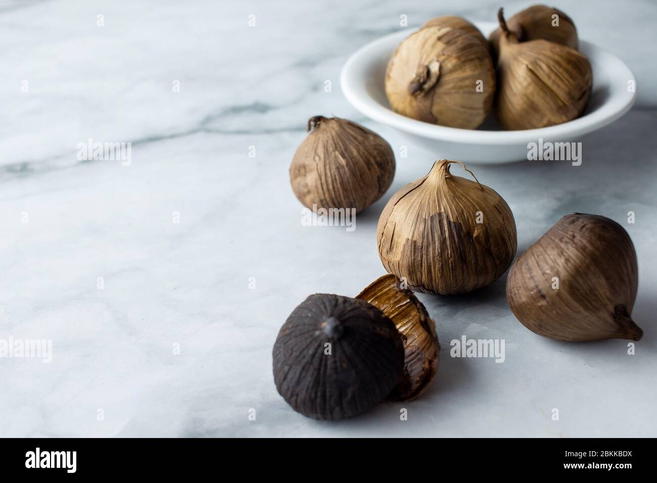 Un gruppo di aglio nero, bulbo d'aglio solo. Un ingrediente alimentare, o comunemente usato per la theraphy olistica dell'alimento. Foto Stock