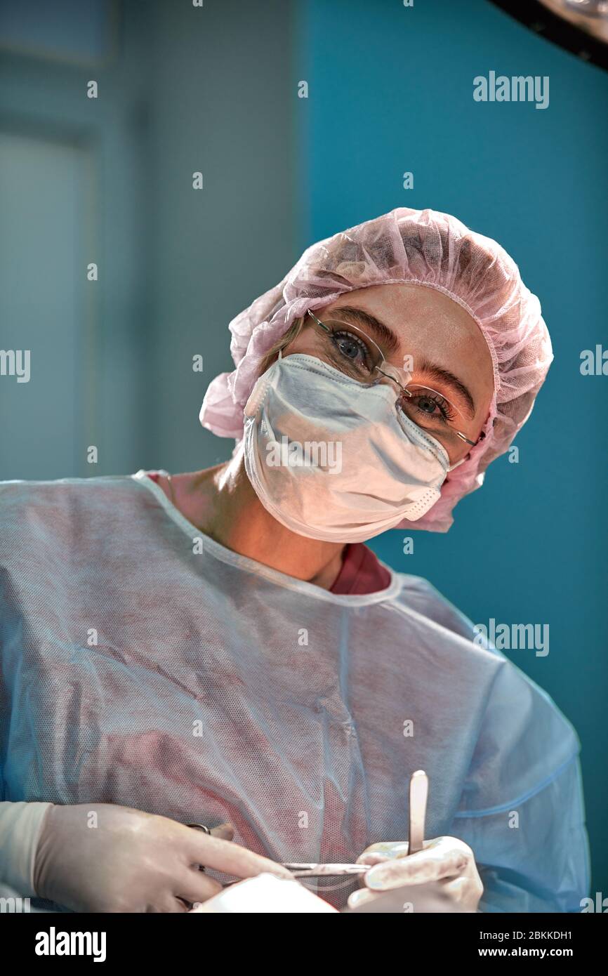 Close up ritratto di giovane donna medico chirurgo di indossare la maschera protettiva e hat durante l'operazione. La sanità, l'istruzione medica, concetto di chirurgia Foto Stock