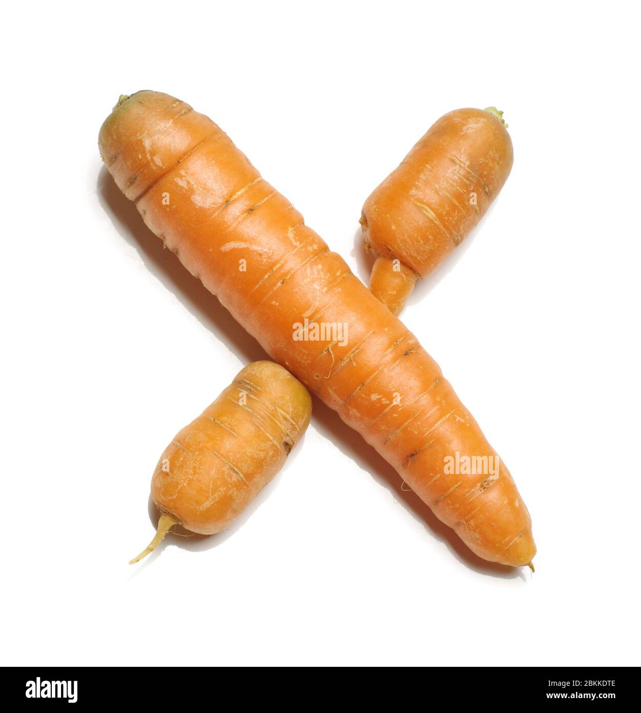 Lettera alfabetica X disposta da carote fresche organiche isolate su sfondo bianco Foto Stock