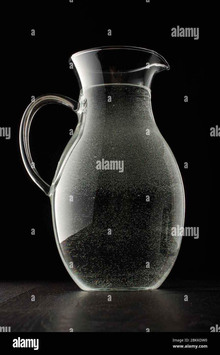 Serbatoio dell'acqua in vetro con piccole bolle completamente riempite isolato su sfondo nero Foto Stock