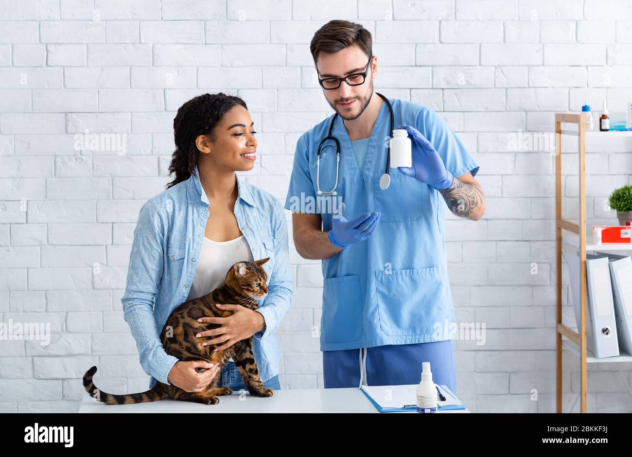 Proprietario di gatto tabby e medico veterinario con meds in ospedale animale Foto Stock
