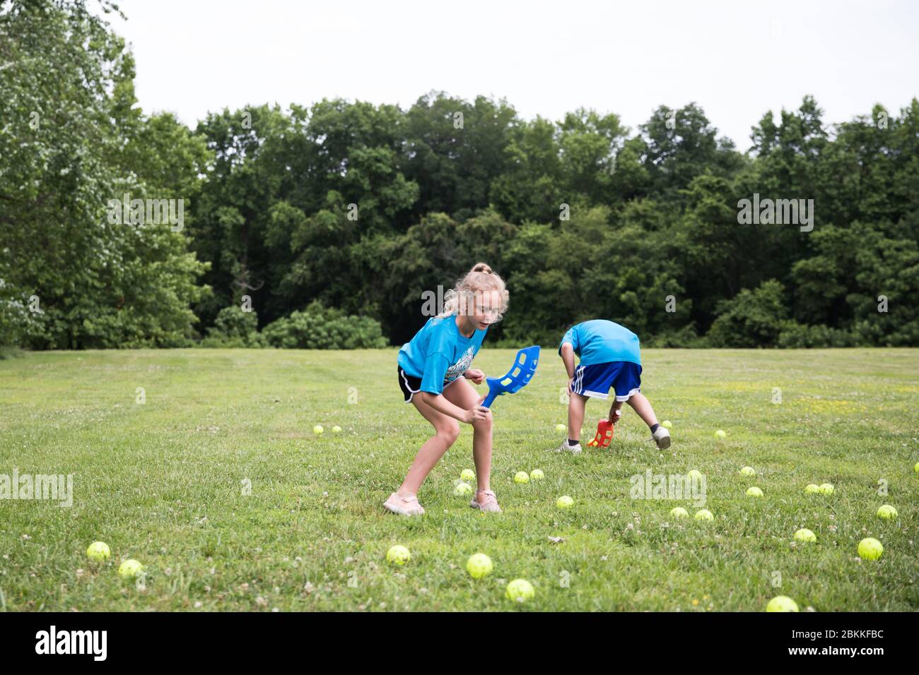 Ragazza con capelli ricci biondi gioca a Lawn Games al Field Day a scuola Foto Stock