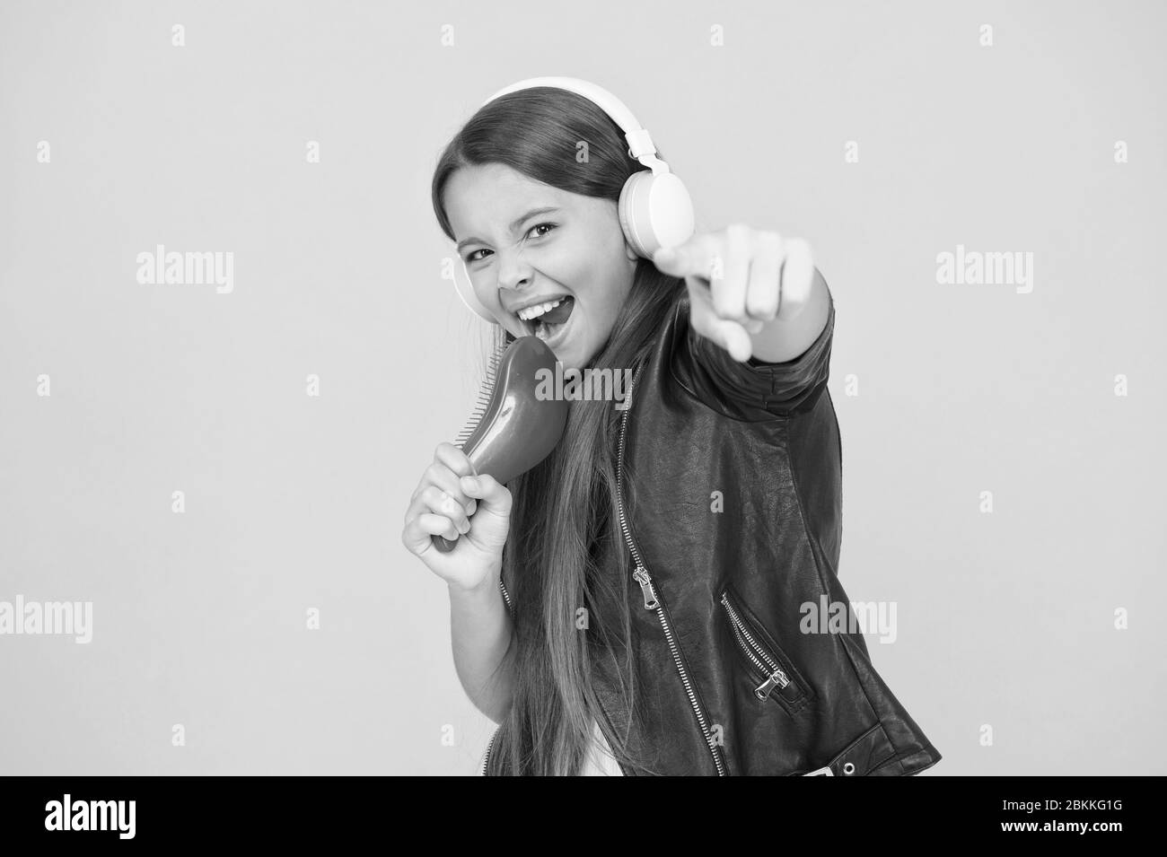 La sintesi vocale. Piccola ragazza ascoltare musica cuffie. Concetto di hobby. Intrattenere se stessa di essere creativi. Educazione musicale. Spazzola per capelli di canto mic. Studio di registrazione. Bella voce. Sviluppo di voce. Foto Stock