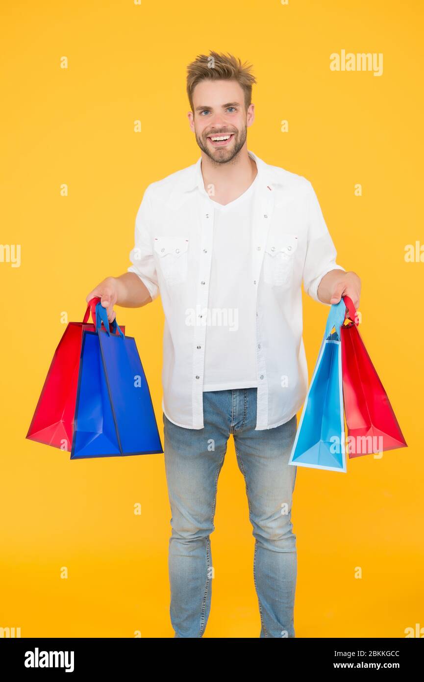 Il modo migliore per rilassarsi. Come risparmiare denaro durante la vendita. Concetto di cyber monday. Articoli per uomo. Ragazzo felice del suo acquisto. Shopping online di successo. Shopping maschile in possesso di pacchetti. Shopping bag con merci. Foto Stock