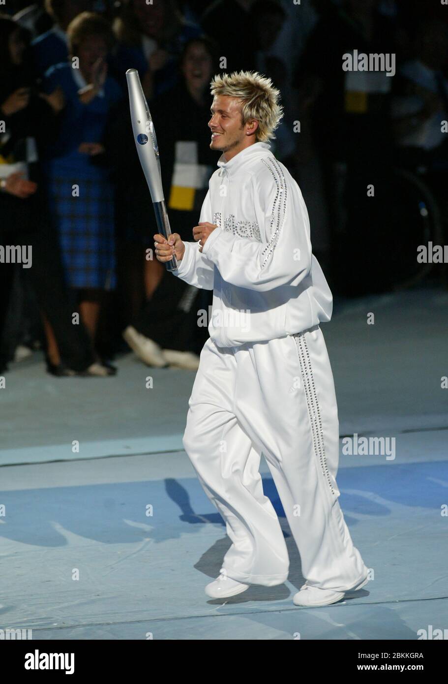 MANCHESTER - LUGLIO 25: Il giocatore di calcio britannico David Beckham che tiene la Jubilee Baton corre nello stadio del City of Manchester Stadium durante il 2002 Foto Stock