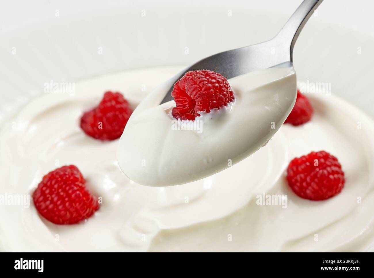 cucchiaio di yogurt greco con lampone, primo piano Foto Stock